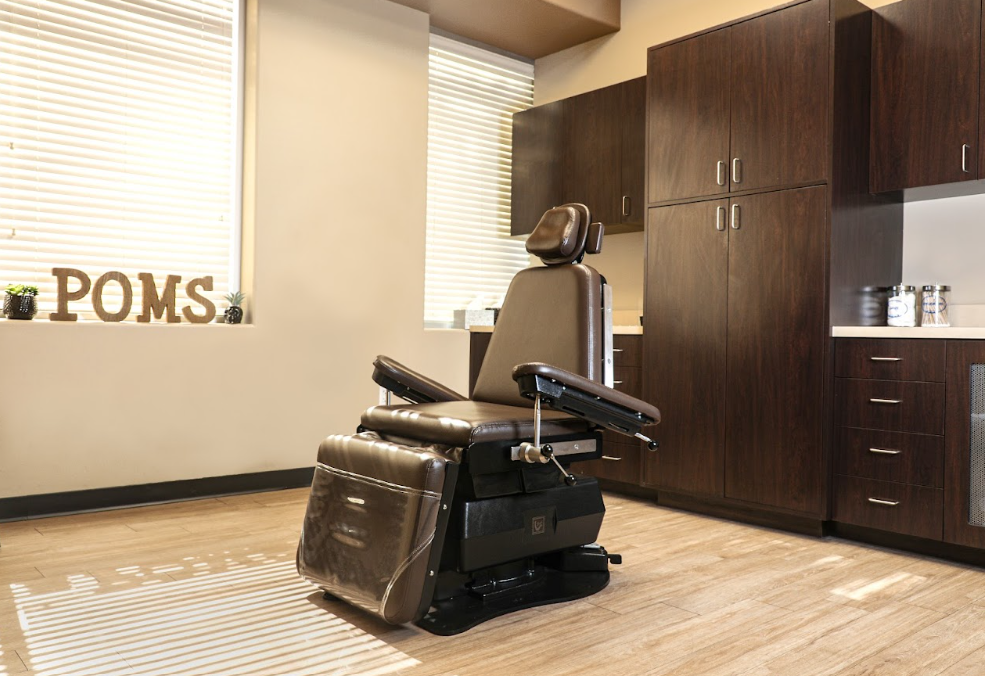 POMS dental treatment room with exam chair and dark wood cabinets
