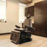 POMS dental treatment room with exam chair and dark wood cabinets